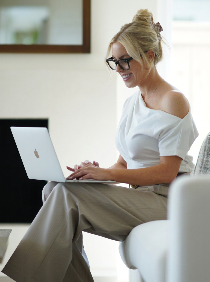 The founder working on a laptop while seated on a light sofa