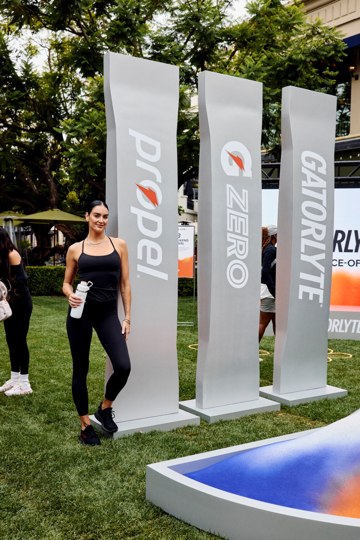 Athlete leaning against Propel, G Zero, and Gatorlyte branded towers on a lawn